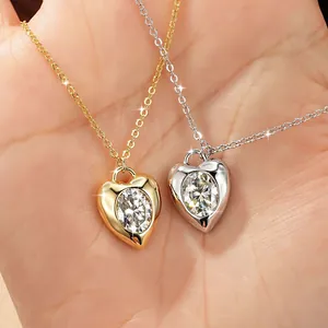 Macro view of two heart necklaces with 2 carat moissanite stones in gold and silver