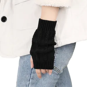 Nahaufnahme von schwarzen gestrickten fingerlosen Handschuhen mit weicher Zopfmuster-Textur