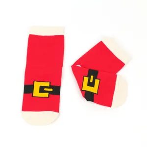 Detail of red Christmas socks featuring a Santa Claus belt design and white trim.