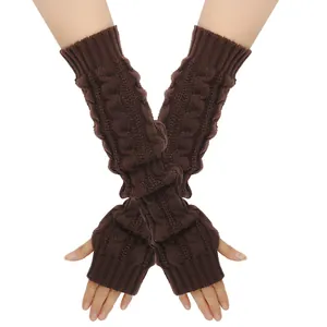 Detailweergave van dikke bruine kabelgebreide vingerloze armwarmers op witte achtergrond