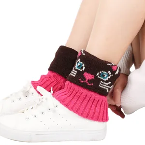 Gros plan de jambières tricotées avec motif chat mignon portées sur des baskets blanches
