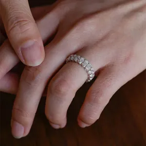 Makroansicht eines eleganten D-Farbe-Moissanit-Eternity-Rings an einer Frauenhand