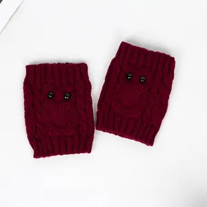 Detailed view of burgundy knitted boot cuffs featuring a cute owl face with black bead eyes