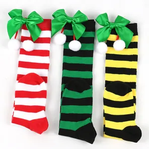 Detail view of colorful striped Christmas knee-high socks for kids with green satin bows