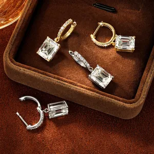 Close-up detail of elegant emerald-cut moissanite hoop earrings in gold and silver finishes