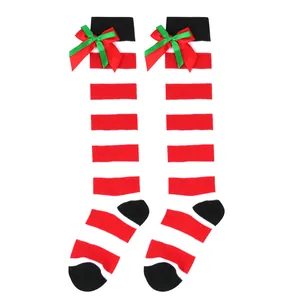 Pair of striped Christmas over-the-knee socks for girls with festive green and red bows.
