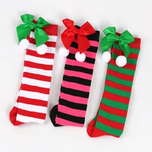 Three pairs of striped Christmas high socks with cute decorative bows and pom-poms.