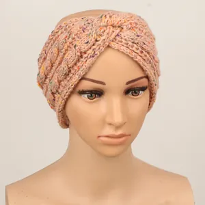 Vue détaillée d'un bandeau d'hiver tricoté de couleur pêche avec des mouchetures colorées.