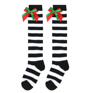 Close-up of children's Christmas knee-high socks with striped pattern and red-green bows