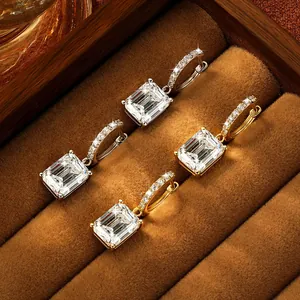 Macro detail of emerald-cut moissanite hoop earrings in gold and silver finish