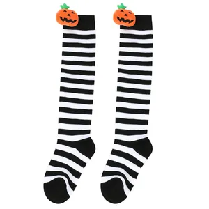 Detailed macro view of Halloween striped knee-high socks with plush pumpkin doll decor.