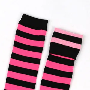 Close-up detail of girls' soft pink and black striped high socks with knit ribbed cuffs