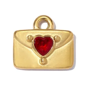 Detailansicht eines goldenen Umschlaganhängers mit einem roten herzförmigen Schmuckstein