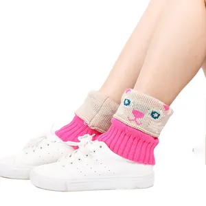 Vue rapprochée des guêtres roses en tricot avec un joli motif jacquard de chat