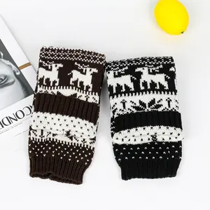 Detailed view of knitted Christmas leg warmers with reindeer and snowflake patterns.