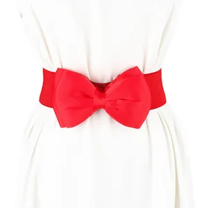 Detail view of a vibrant red elastic waistband featuring a large chiffon bow design.