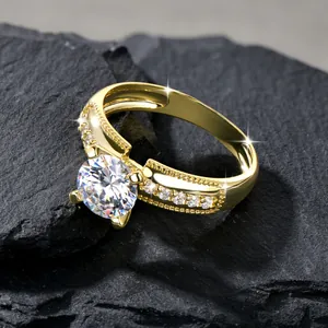Nahaufnahme eines 14k goldgefüllten Rings mit einem großen klaren Stein auf dunklem Fels