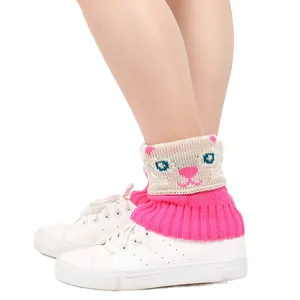 Gros plan de jambières en tricot rose avec un motif de chat mignon sur baskets blanches.