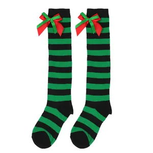 Detail of children's green and black striped over-the-knee Christmas socks with bows