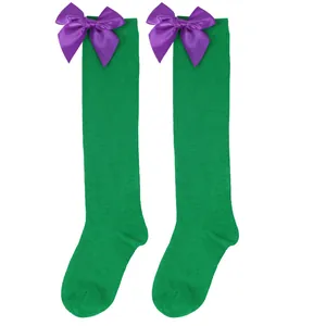 Green knee-high socks for girls featuring large purple satin bows for Halloween party