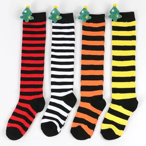 Detailed view of striped children's Christmas knee-high socks with cute plush trees