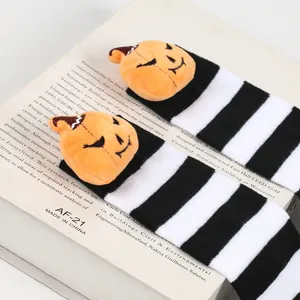 Detailed view of Halloween striped socks featuring cute plush pumpkin demon characters