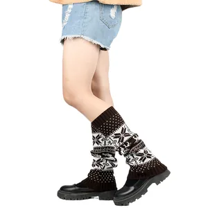 Detailed view of thick knitted leg warmers featuring a classic brown and white snowflake pattern