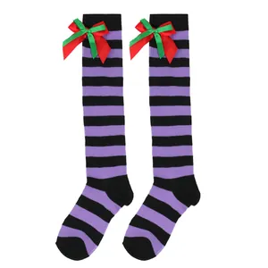 Detailed view of girls purple and black striped knee high socks with red green bowknots