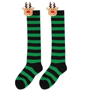 Close-up detail of green and black striped Christmas socks with cute plush reindeer heads