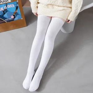 Gros plan d'un mannequin portant des chaussettes montantes en coton blanc élastique.