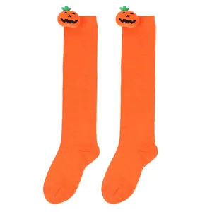 Detail of orange children's over-the-knee socks with cute plush pumpkin toppers