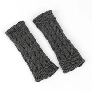 Close-up of dark grey cable knit fingerless gloves and warm winter arm warmers.
