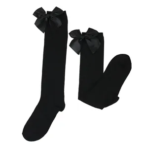Detailed view of black knee-high socks with large satin bows for girls