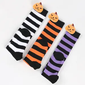 Close-up detail of Halloween pumpkin plush mascot on striped long socks for kids