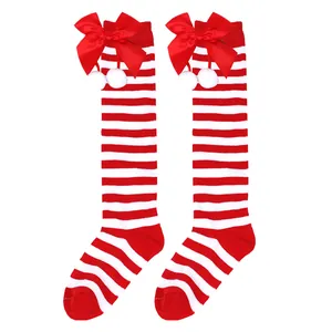 Festive red and white striped girls' knee-high socks with red bows and white pompoms