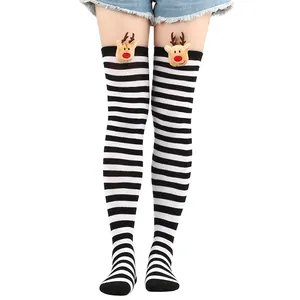 Close-up of festive Christmas over-the-knee socks featuring black and white stripes and reindeer