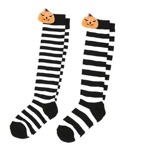 Detailed macro view of Halloween striped long socks with cute plush pumpkin charms