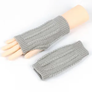 Nahaufnahme der grauen Strickstruktur an fingerlosen Armstulpen für Winterkomfort