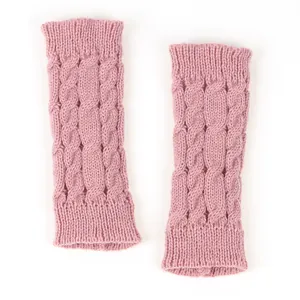 Detailed macro view of pink cable-knit texture on warm winter fingerless arm warmers