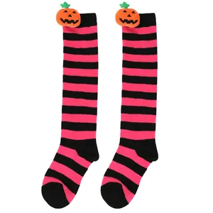 Detailed view of the plush pumpkin decoration on striped pink and black socks