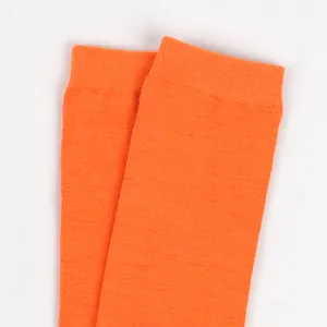 Detailed macro view of vibrant orange knit children's socks showing elastic ribbed cuffs