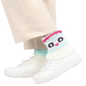 Vue détaillée de jambières en tricot avec motif de dessin animé et baskets blanches de sport