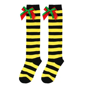 Macro view of yellow and black striped over-the-knee socks with red and green bows