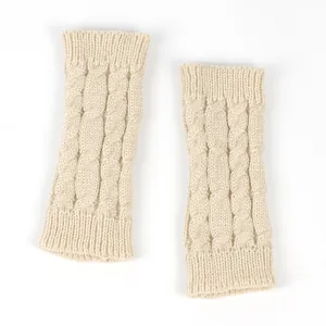 Close-up of beige cable-knit fingerless gloves with soft wool texture.