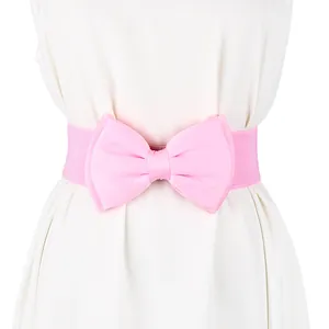 Detail shot of a pink chiffon bow belt with an elastic stretch band on a white dress