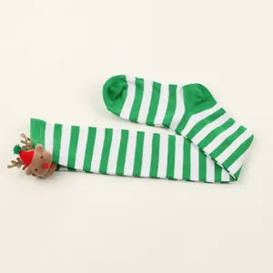 Close-up of green and white striped Christmas over-the-knee socks with reindeer plush