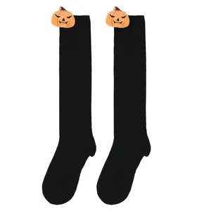 Close-up of Halloween children's black knee high socks with plush pumpkin doll details