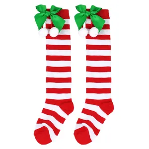 Detail view of festive red and white striped Christmas socks with green bows