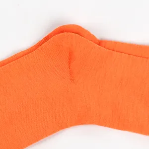 Macro view of bright orange knitted children's sock heel showing fine texture detail