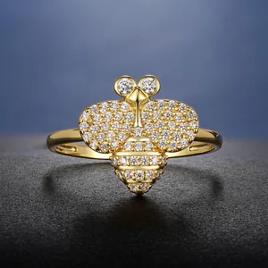 Détail macro d'une bague abeille en or de luxe sertie de cristaux étincelants pavés